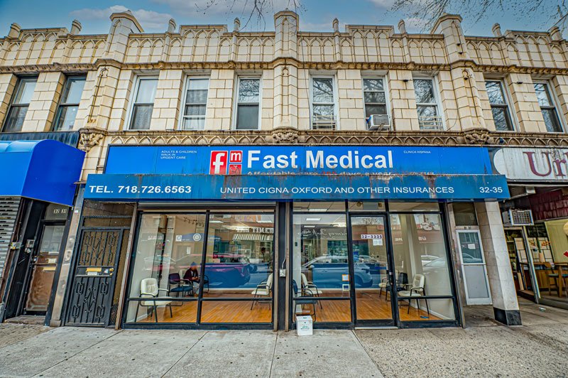 A street-level view of a beige brick building with a blue "Fast Medical" sign and glass doors revealing a waiting area with chairs. The sign lists accepted insurances, a contact phone number, and welcomes walk-ins. DOT Medical Card NYC at Fast CDL Medical